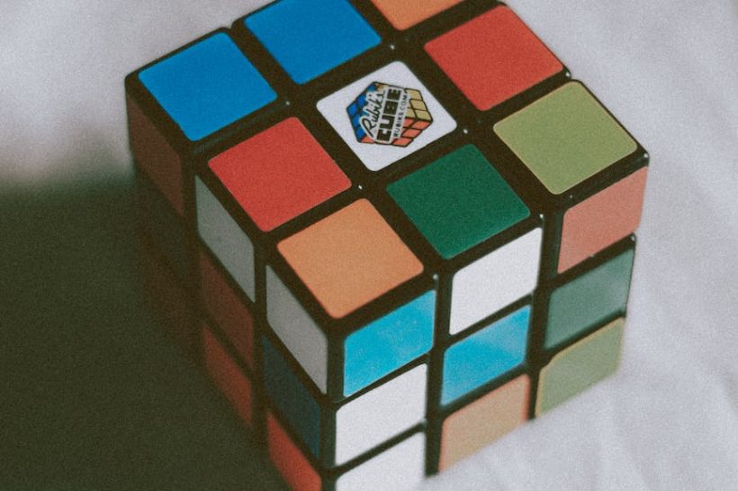 multicolored magic cube placed on table