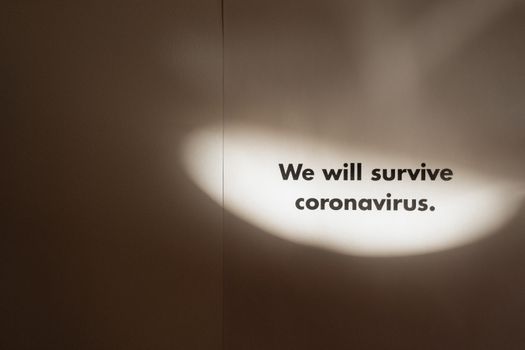 Motivational text "We will survive coronavirus" with spotlight effect.