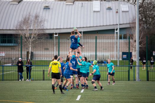 Exciting rugby lineout action at a sports field in Manchester, England.