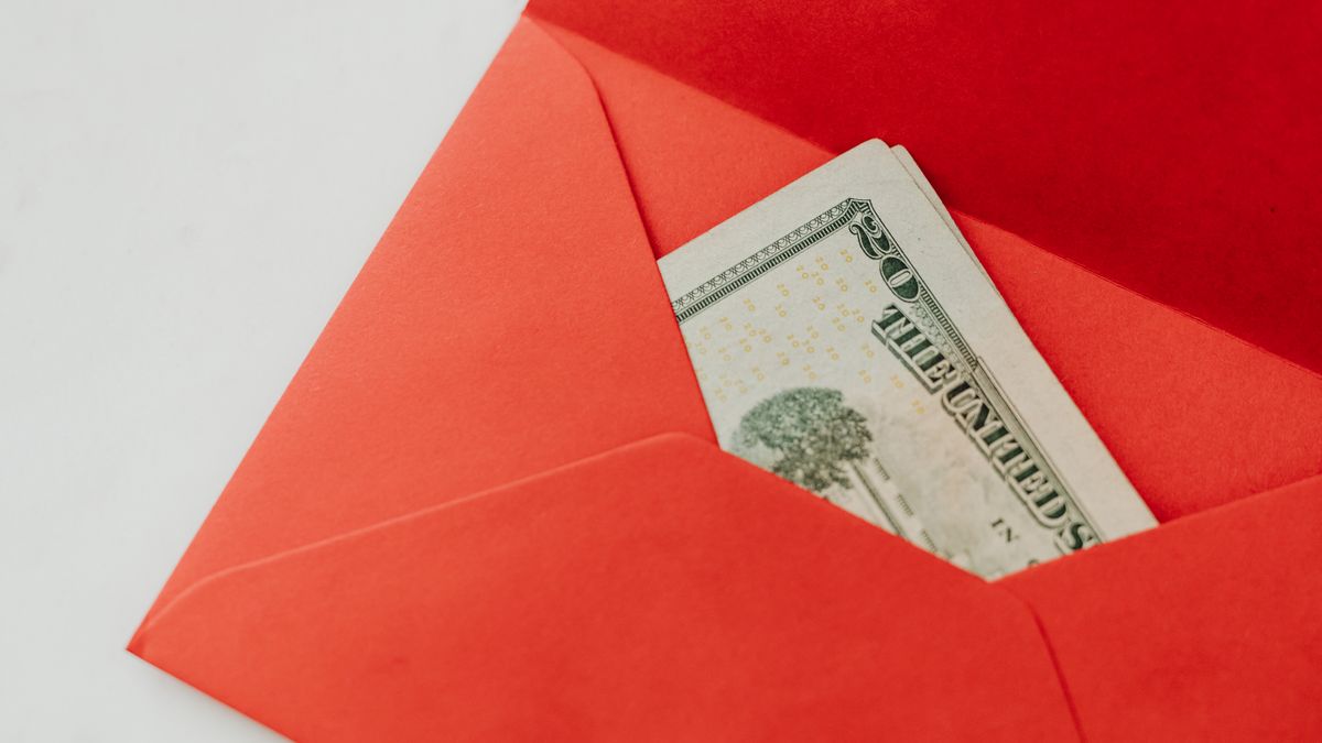 A red envelope containing U.S. dollar bills, symbolizing wealth and gifting.