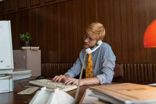 Vintage scene of a businessman on a corded phone at a retro office desk with classic documents.