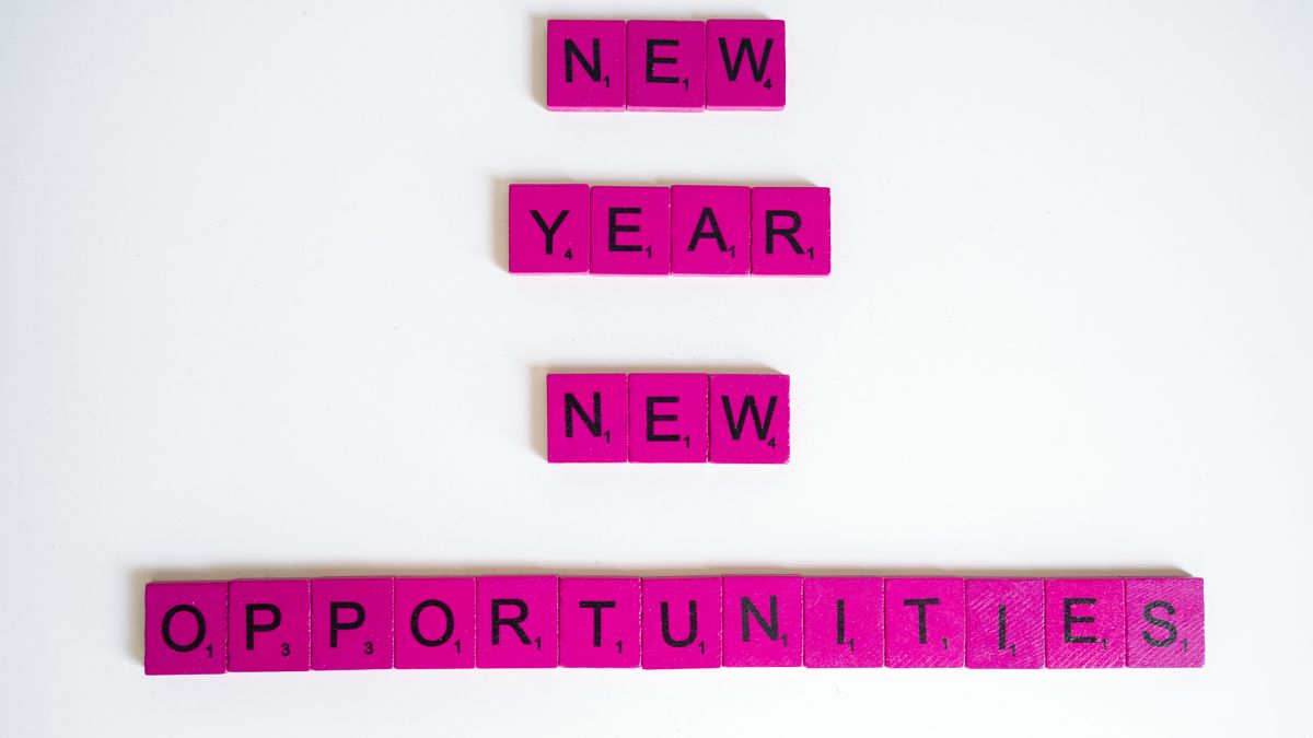 Pink scrabble tiles spelling 'New Year New Opportunities' on white background.