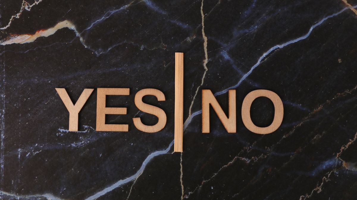 A stylish contrast of wooden letters 'Yes' and 'No' on dark marble background.
