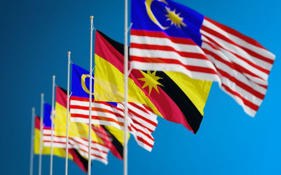 Vibrant display of Malaysian and Sarawak flags symbolizing unity and patriotism against a clear blue sky.