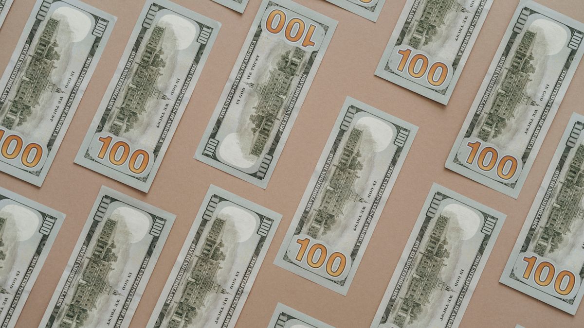 Patterned display of 100 US dollar bills, showcasing wealth and finance themes.