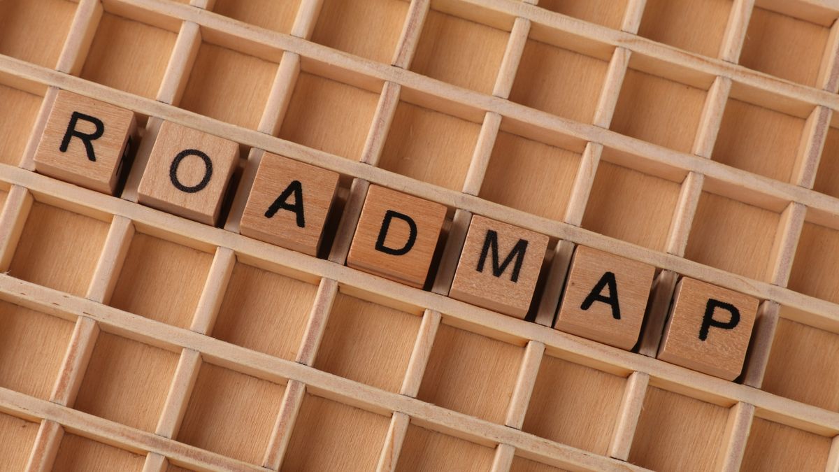 Wooden letter blocks forming the word 'ROADMAP' on a wooden grid background.