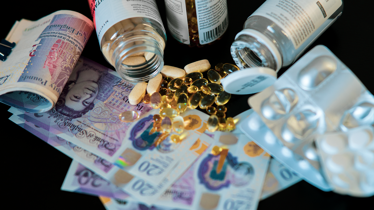 A still life of supplements, pills, and currency with a dark backdrop.