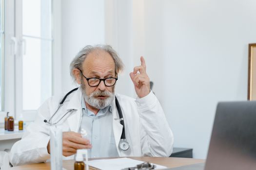 Senior doctor in white coat having an online consultation. Medical professional using technology for healthcare.